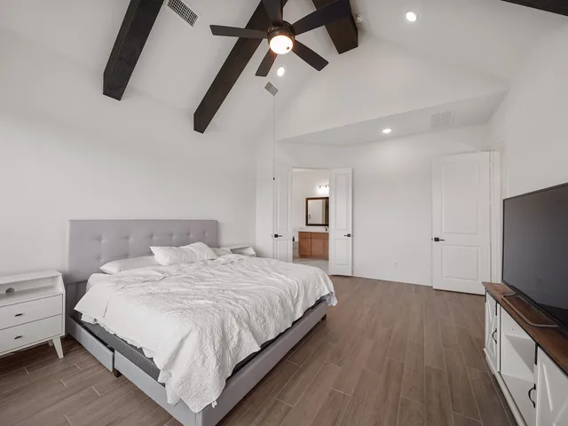 a bedroom with a bed and a flat screen tv