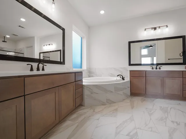 a bathroom with a tub sink and mirror