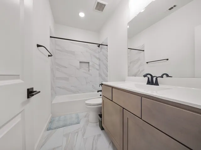 a bathroom with a sink a toilet a mirror and shower
