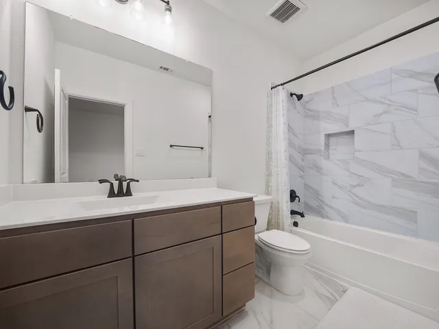 a bathroom with a sink toilet vanity and shower