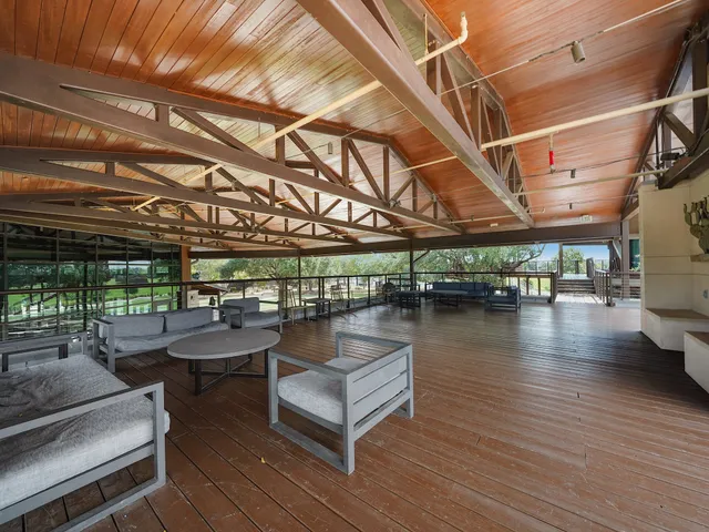 a view of a patio with dining table and chairs with wooden floor