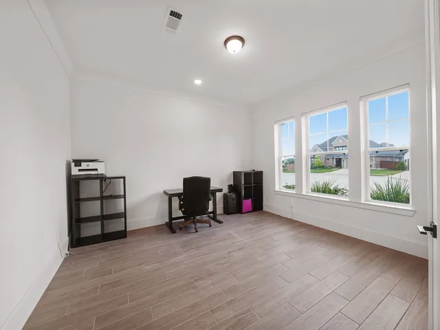 a view of a workspace with furniture and a window
