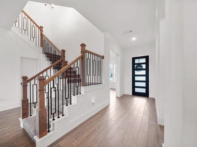 a view of staircase with wooden floor and white walls