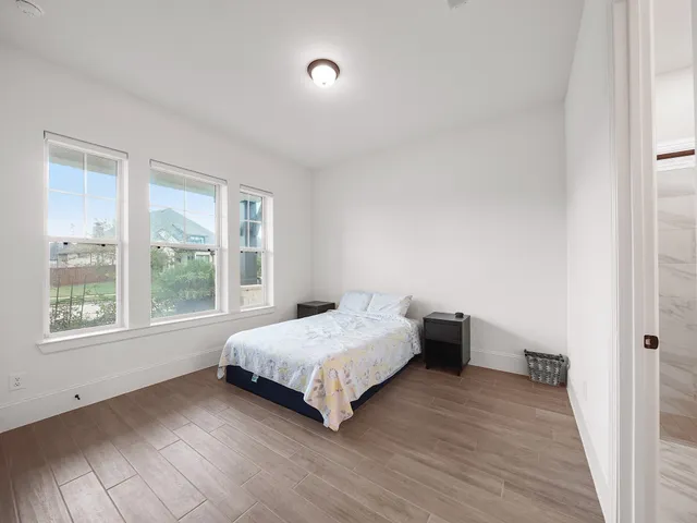 a bedroom with a bed and wooden floor