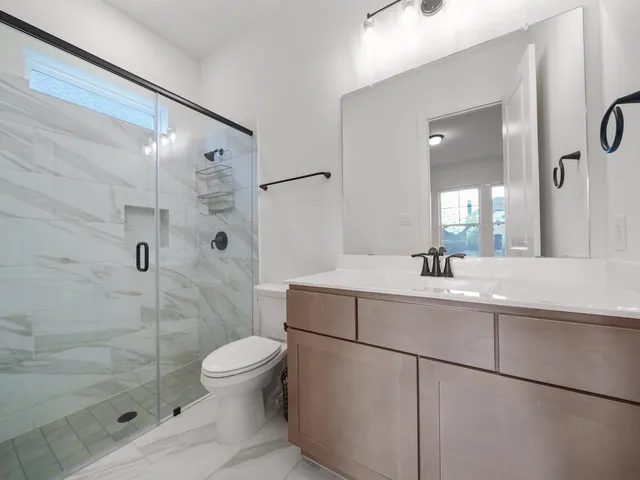 a bathroom with a sink a toilet and shower