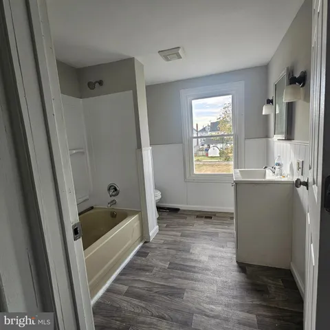 a bathroom with a tub a sink and a window