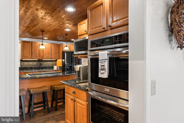 a kitchen with stainless steel appliances granite countertop a stove and a microwave