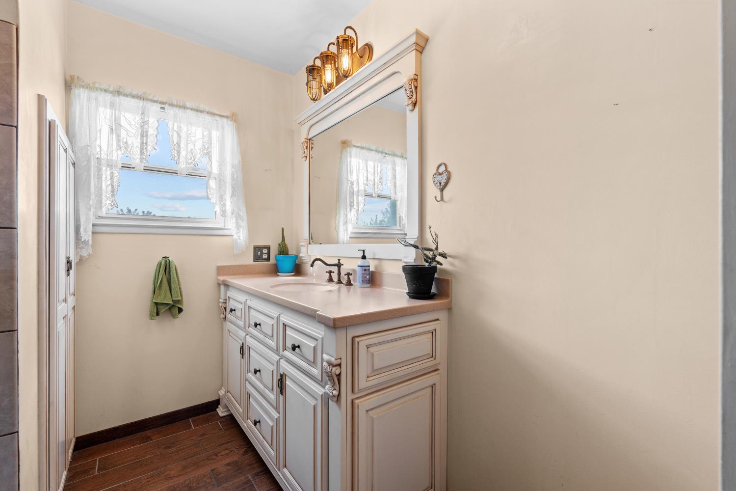 3058 7th Avenue Hanford, CA 93230 - Photo 15 of 38 a bathroom with a sink a mirror and a window
