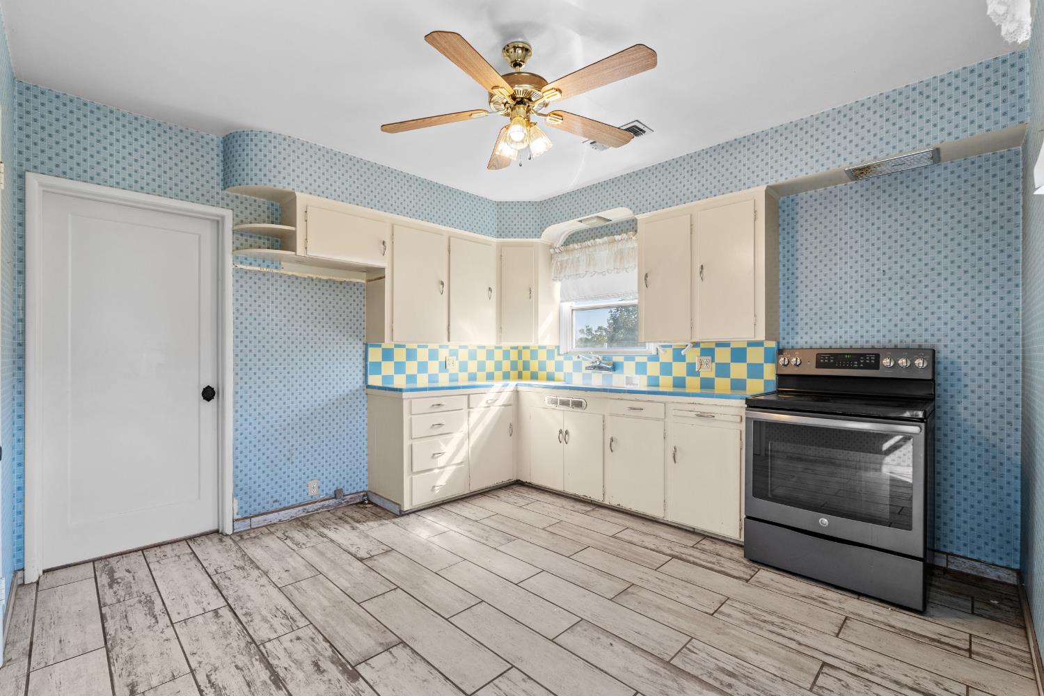 3058 7th Avenue Hanford, CA 93230 - Photo 9 of 38 a kitchen with stainless steel appliances a stove a sink and a refrigerator