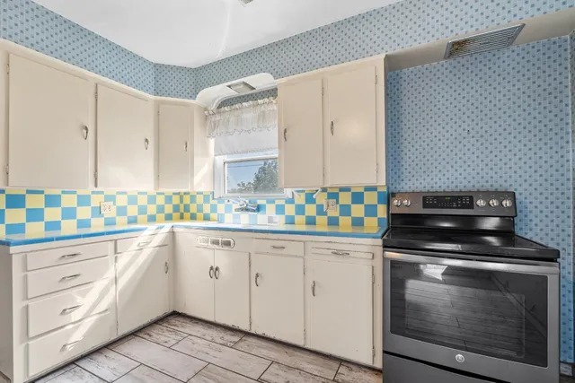 a kitchen with granite countertop white cabinets and appliances