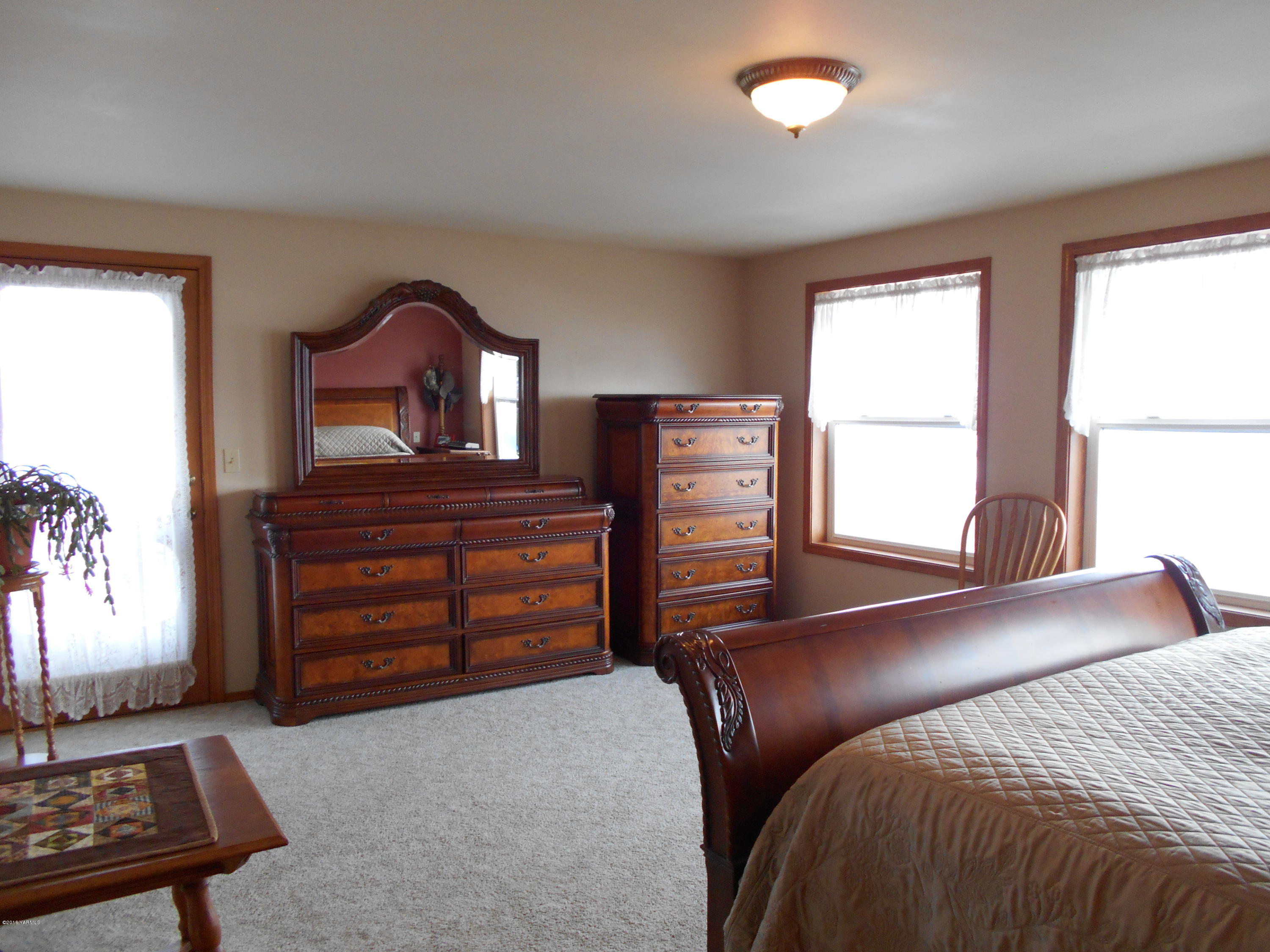 13910 Fisk Road Yakima, WA 98908 - Photo 31 of 48 a bedroom with a bed and a dresser with mirror