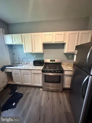a kitchen with a sink a stove and cabinets