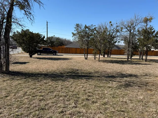 a view of a yard with wooden fence