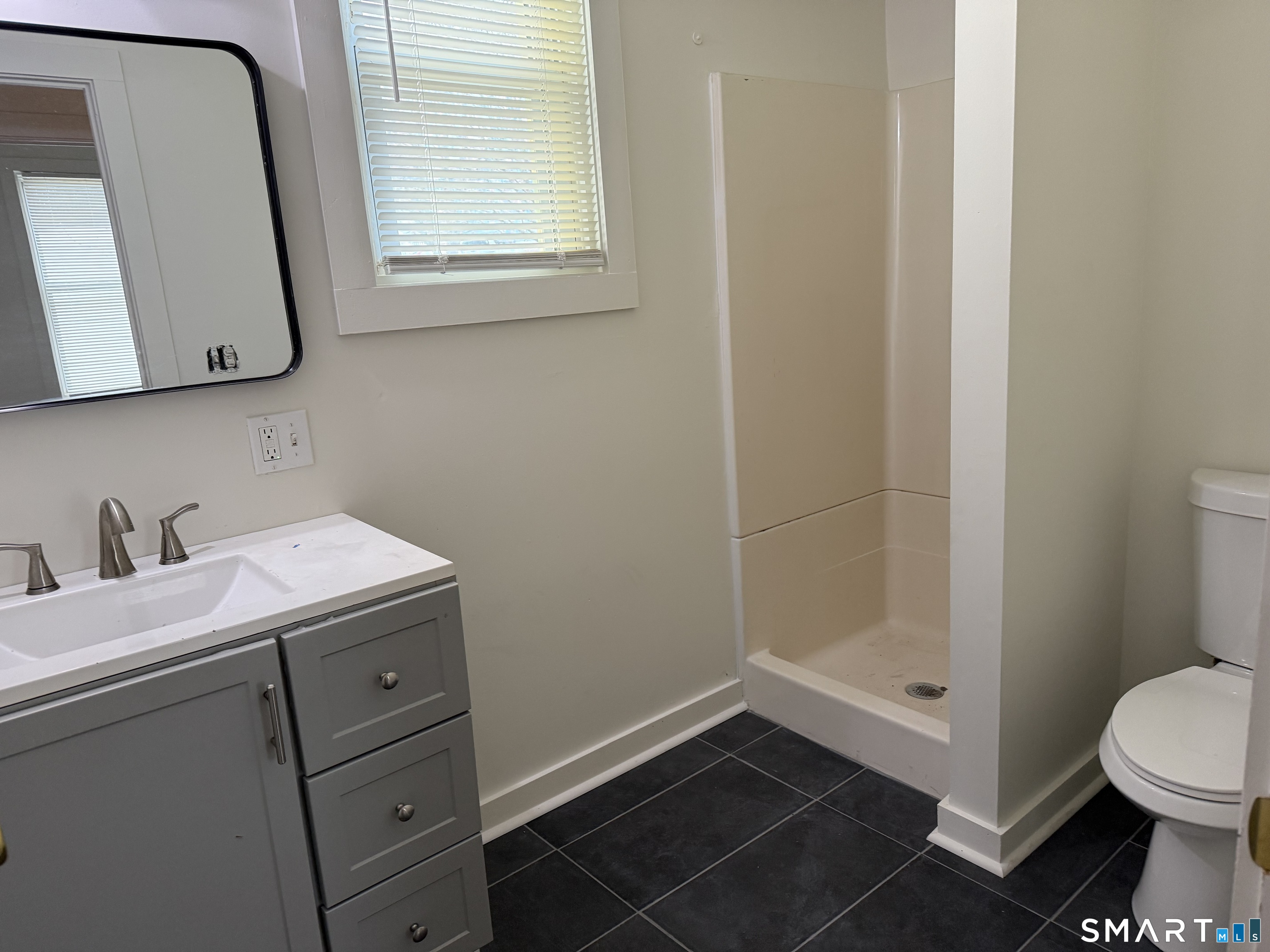 837 Bank Street, Unit 3 New London, CT 06320 - Photo 4 of 5 a bathroom with a sink a toilet and a mirror