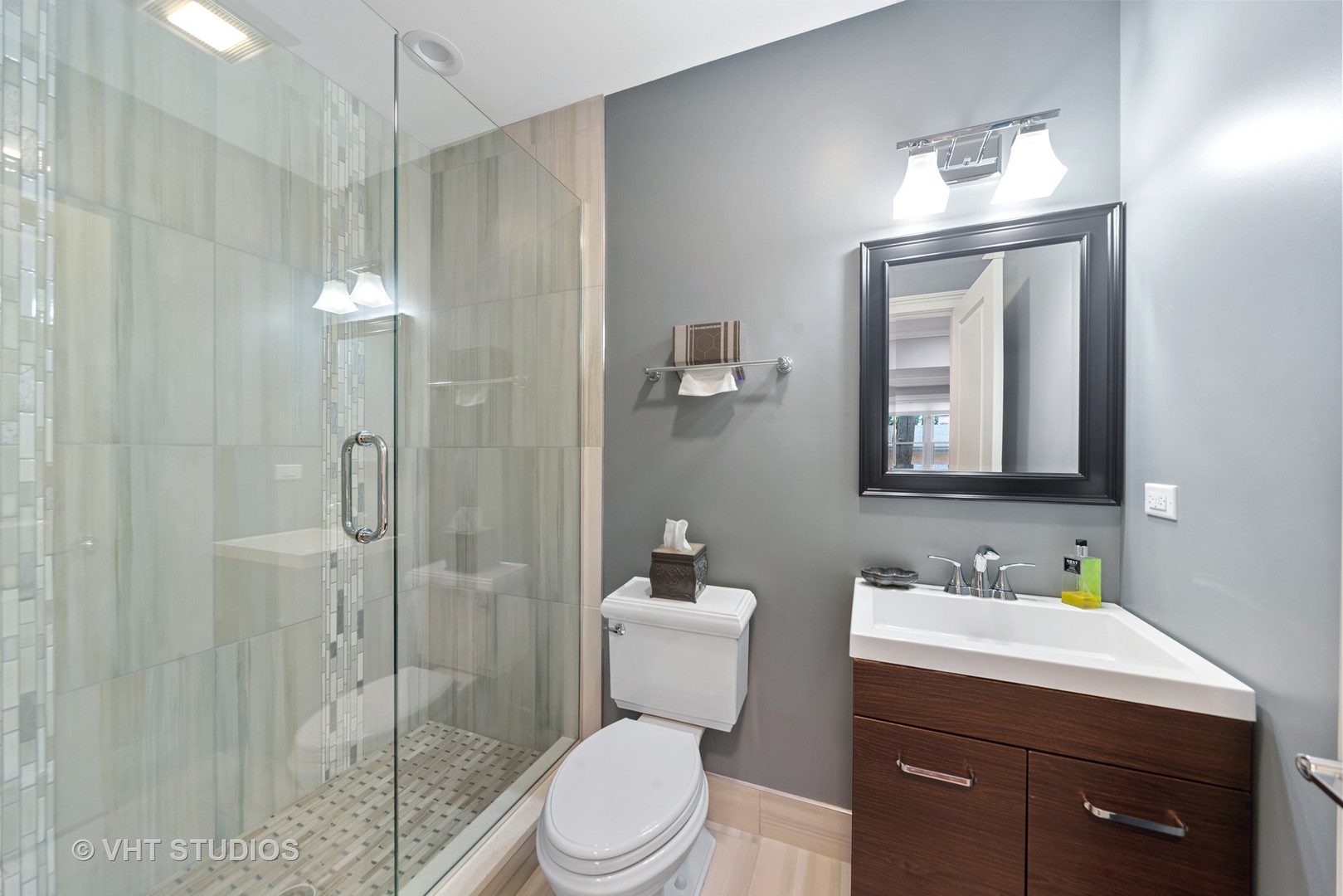 2366 Green Bay Road Highland Park, IL 60035 - Photo 26 of 37 a bathroom with a toilet a sink a glass door a shower a mirror and vanity