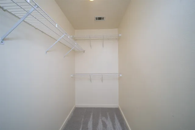 a view of walk in closet with empty racks