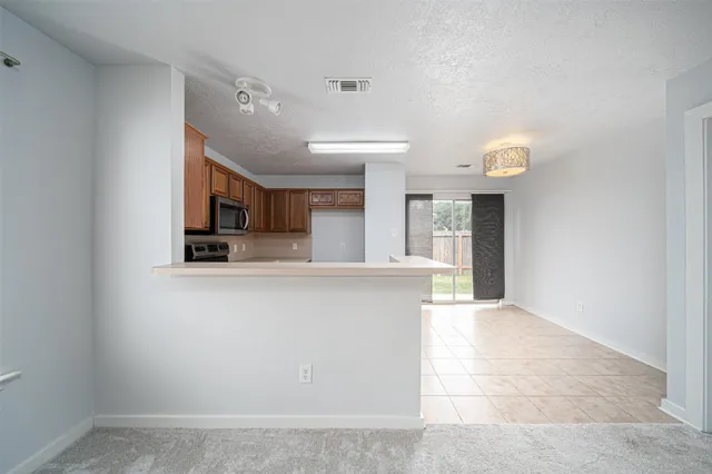 a view of kitchen with cabinets and window