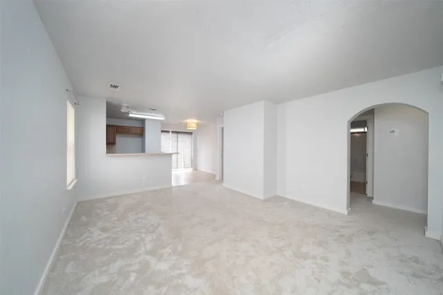 a view of a big room with kitchen and windows