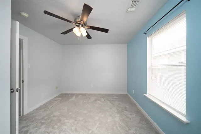 a view of room with a ceiling fan and window