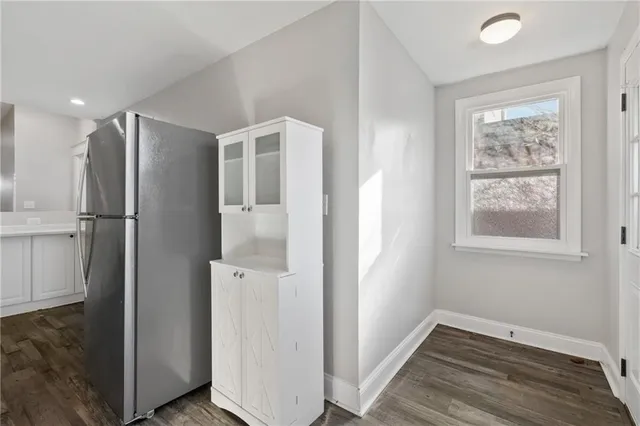 a view of hallway with window and wooden floor