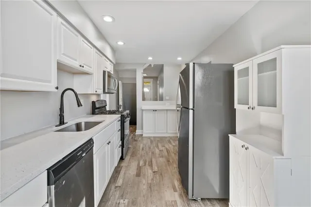 a kitchen with stainless steel appliances a sink stove and refrigerator