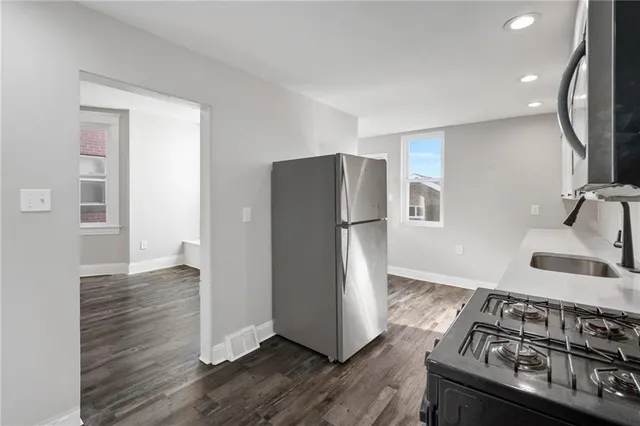 a kitchen with stainless steel appliances granite countertop a refrigerator and a stove