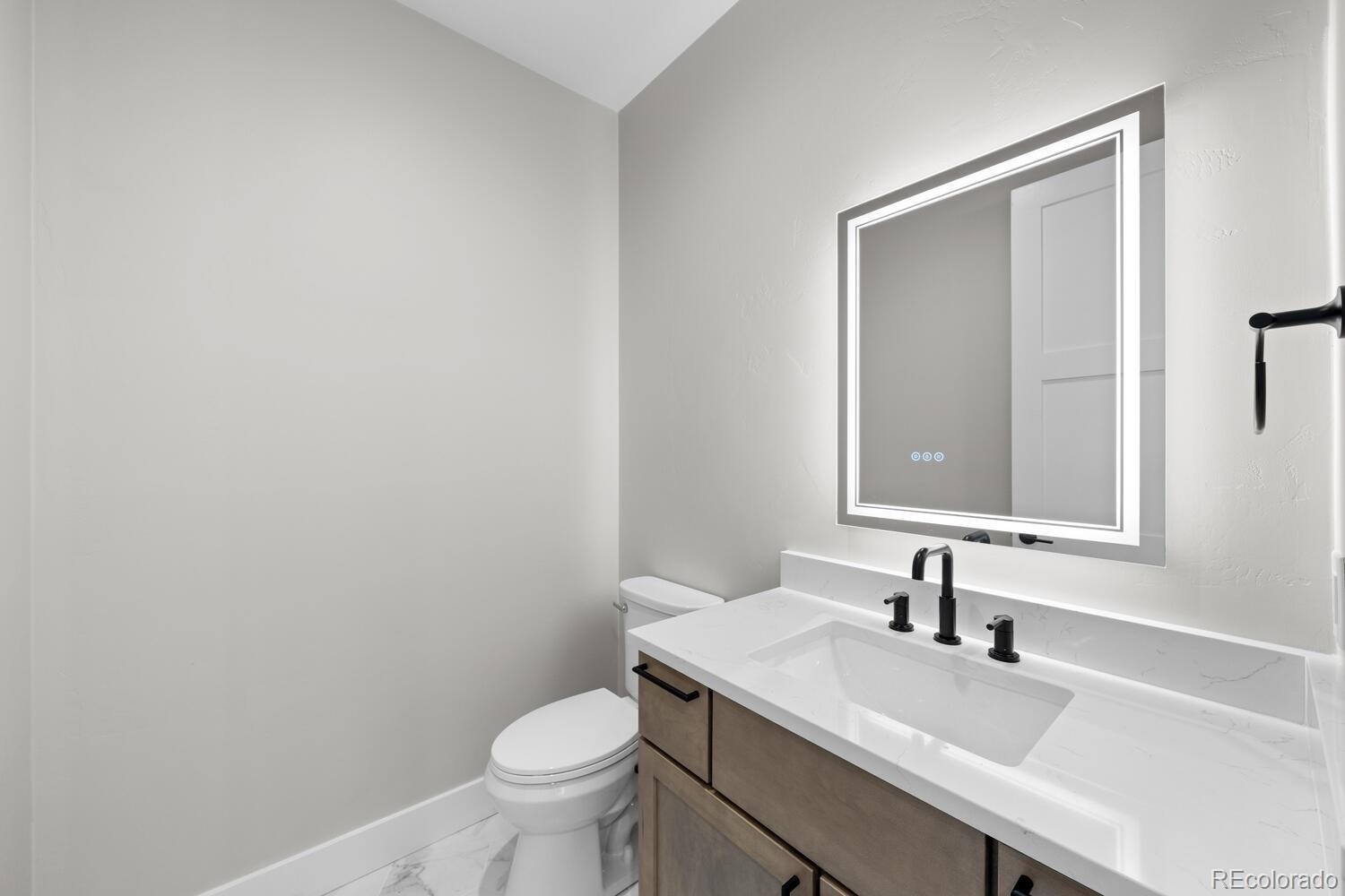 1306 Yates Street Denver, CO 80204 - Photo 14 of 29 a bathroom with a granite countertop sink a toilet and a mirror