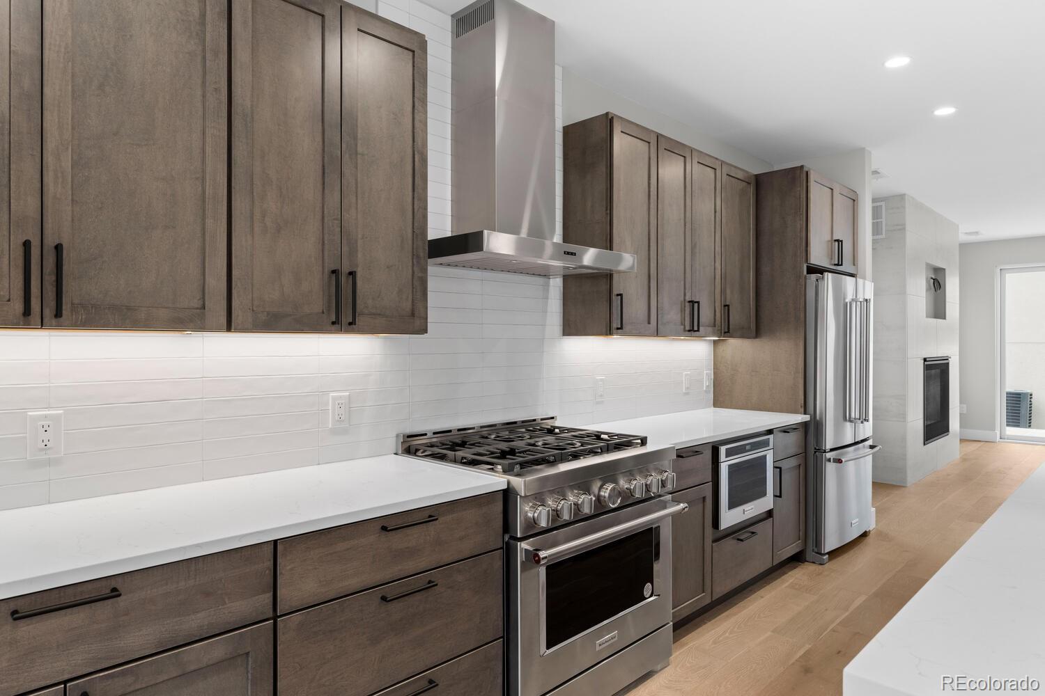 1306 Yates Street Denver, CO 80204 - Photo 3 of 29 a kitchen with stainless steel appliances granite countertop a stove a refrigerator and a cabinets