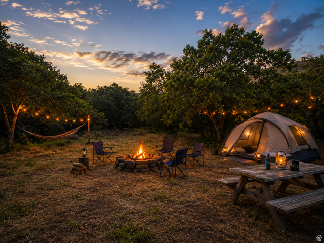 123 West Spring Hollow Road Morgan, UT 84050 - Photo 7 of 13 Expansive outdoor area featuring a stone-ringed fire pit, string lighting, and mature trees