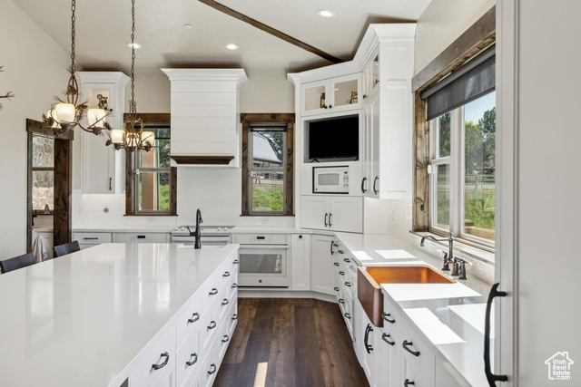 6117 North Rocky Ridge Road Peoa, UT 84061 - Photo 40 of 83 Kitchen featuring pendant lighting, white appliances, white cabinetry, backsplash, and dark hardwood / wood-style flooring