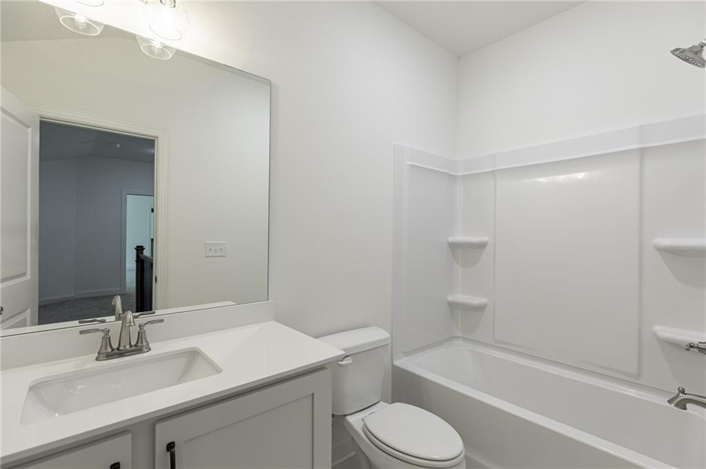 1210 Austin Road Winder, GA 30680 - Photo 48 of 56 a bathroom with a sink toilet vanity and shower