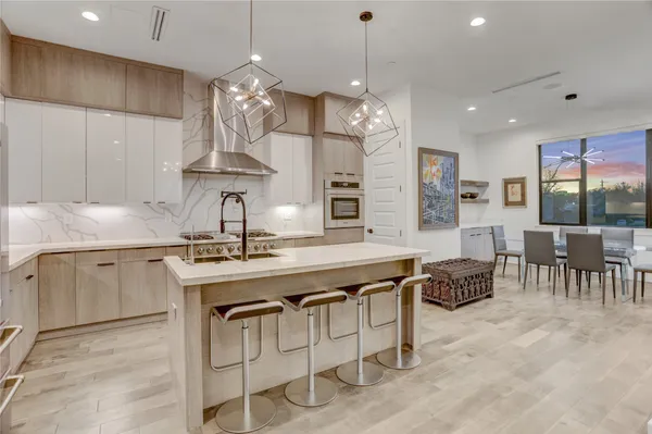 a kitchen with cabinets a sink dining table and chairs