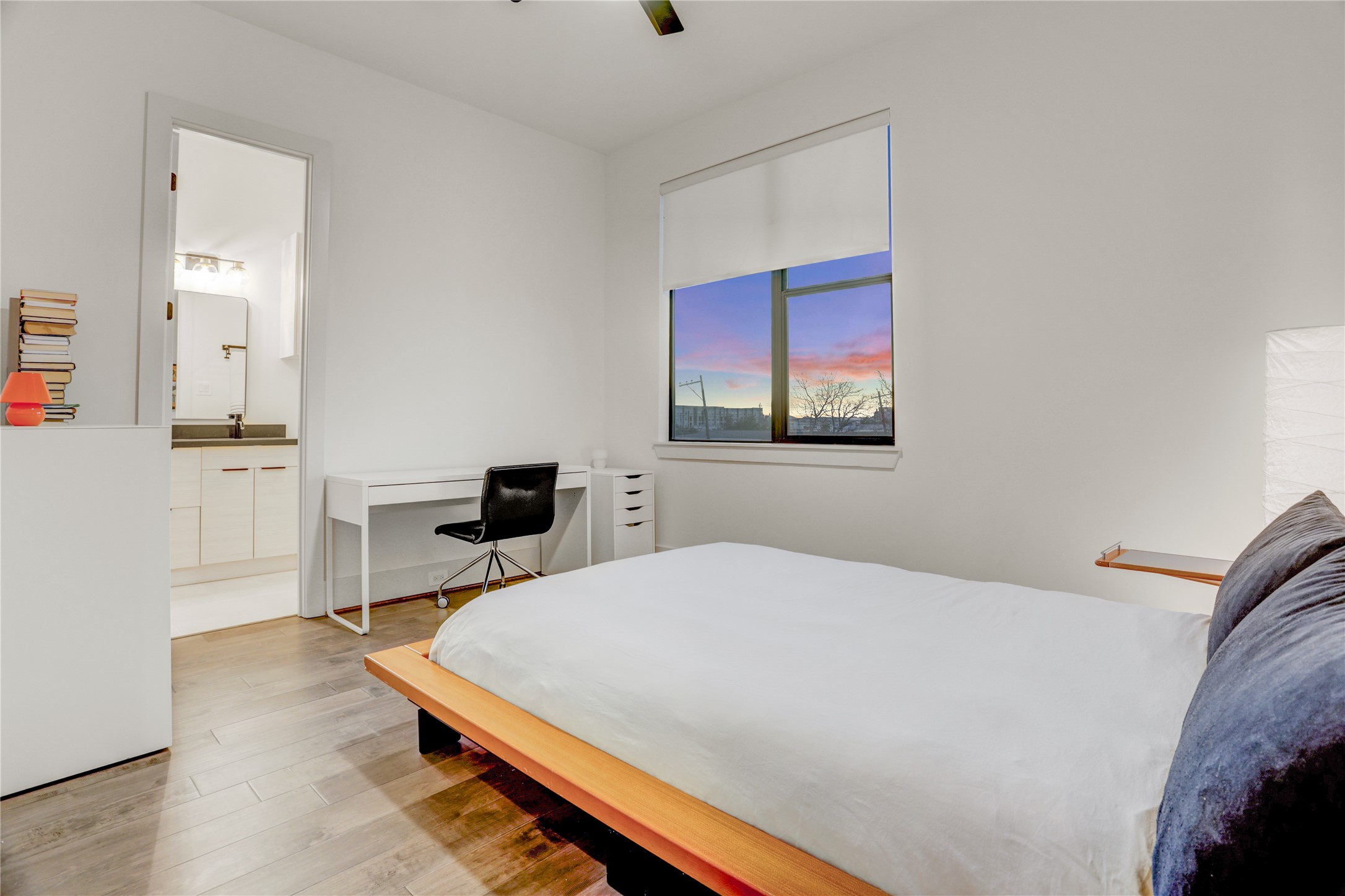 2435 Sheridan Street Houston, TX 77030 - Photo 16 of 25 This bedroom offers another serene retreat with sleek hardwood floors, ample natural light, and a stunning sunset view.