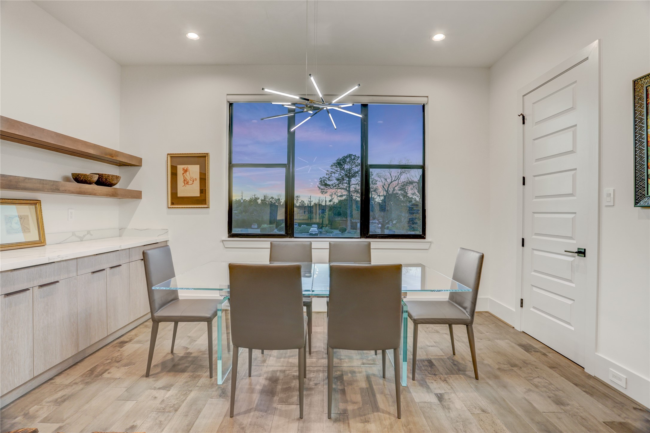 2435 Sheridan Street Houston, TX 77030 - Photo 10 of 25 The elegant dining room features a modern chandelier, large window with sunset views, sleek cabinetry, and a built-in wine cooler.