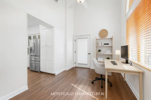a view of a workspace with furniture and a window