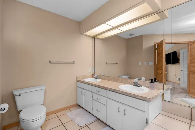 a bathroom with a granite countertop sink a toilet and mirror