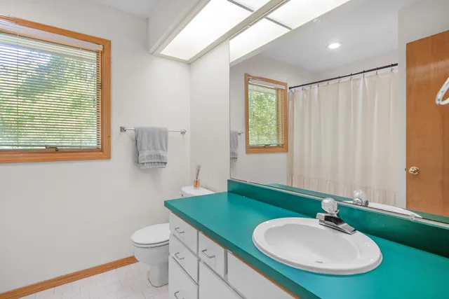 a bathroom with a sink a toilet and mirror