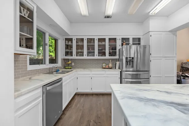 a kitchen with stainless steel appliances a sink and a refrigerator