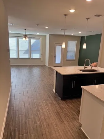 a kitchen with kitchen island a sink and wooden floor