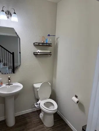 a bathroom with a toilet sink and mirror