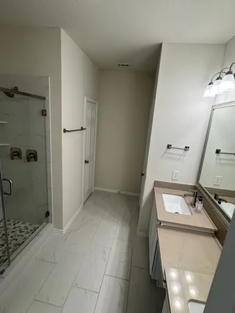 a bathroom with a sink a toilet and shower