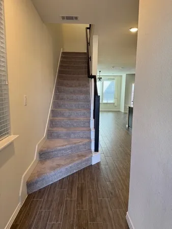 a view of a hallway with wooden floor and staircase