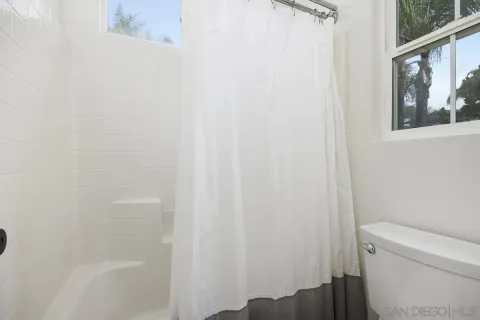 a bathroom with a toilet and a shower curtain