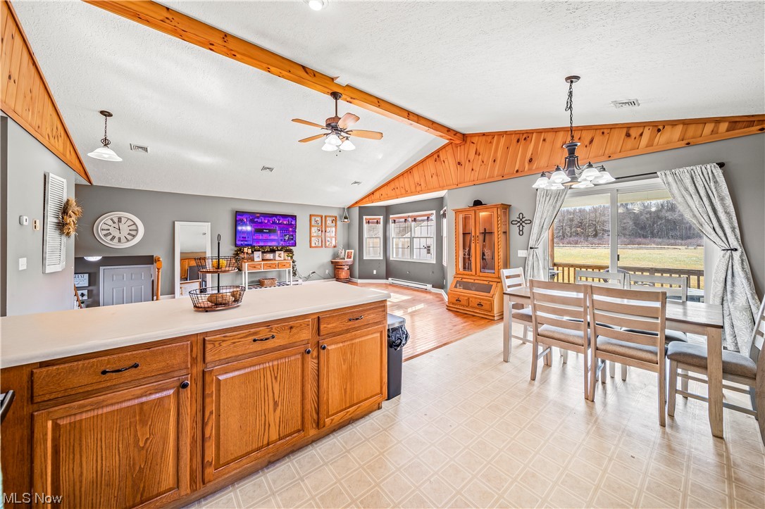 7290 Turner Road Pierpont, OH 44082 - Photo 13 of 36 Kitchen featuring lofted ceiling with beams, ceiling fan with notable chandelier, a textured ceiling, hanging light fixtures, and light tile floors