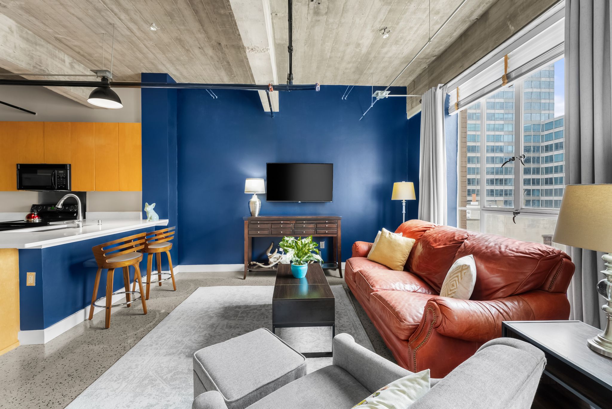 710 Colorado Street, Unit 6E Austin, TX 78701 - Photo 9 of 24 Exposed concrete ceilings complement the modern open-plan living and kitchen space.