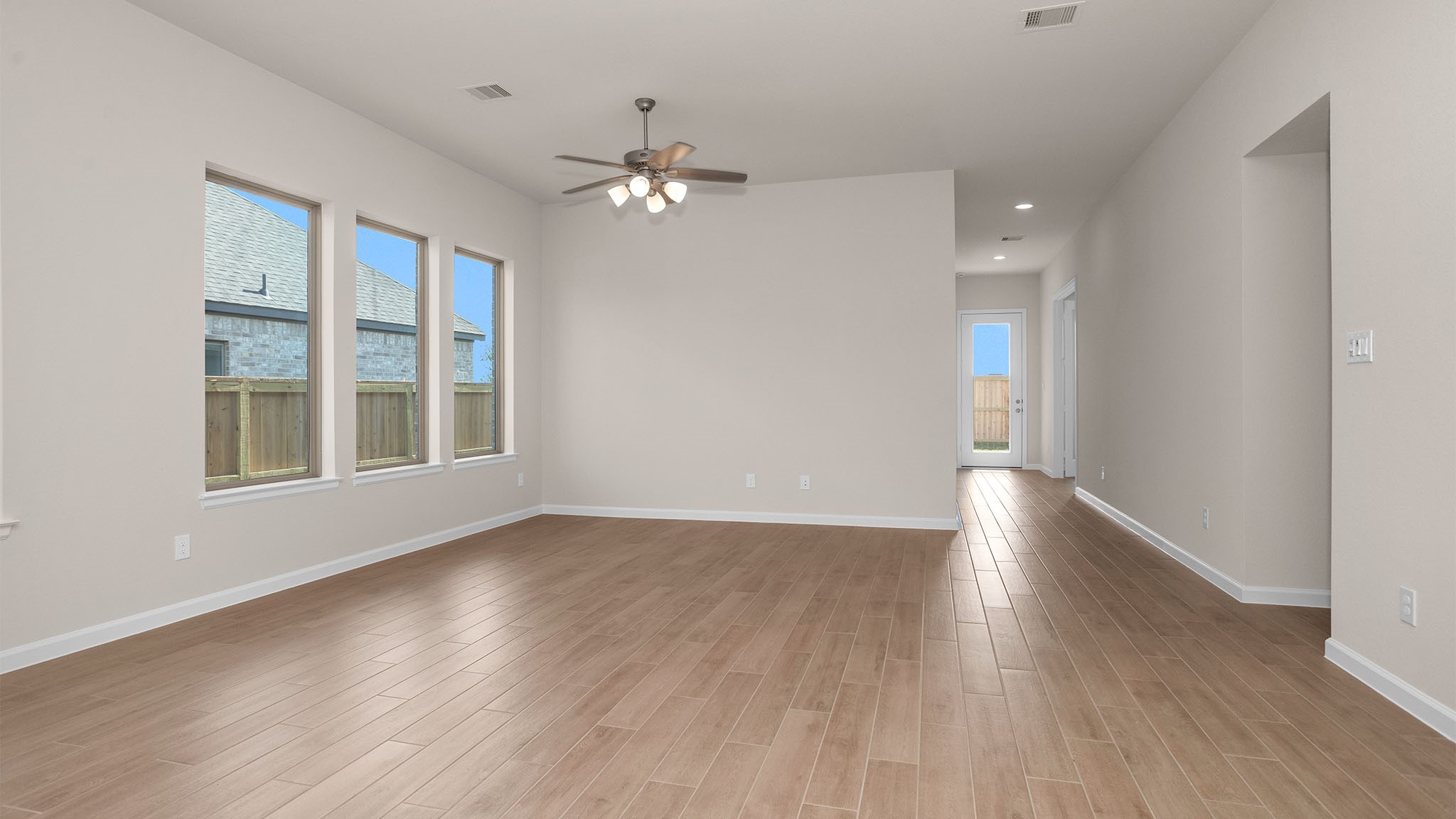 6058 Cottontail Lane Manvel, TX 77578 - Photo 7 of 26 a view of an empty room with wooden floor and windows