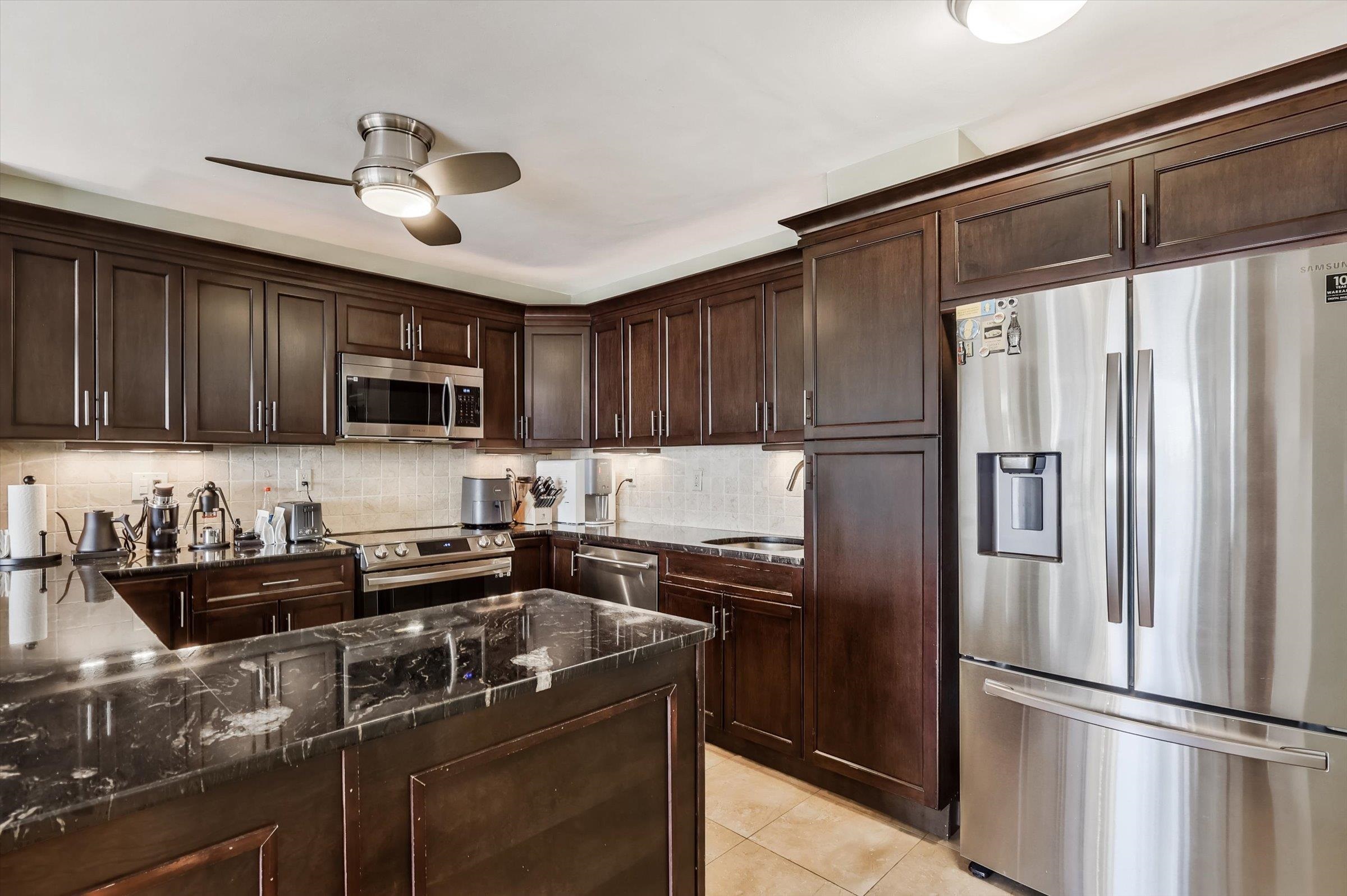 380 Mountain Road, Unit 1015 Union City, NJ 07087 - Photo 17 of 43 a kitchen with stainless steel appliances granite countertop a refrigerator a sink and wooden cabinets
