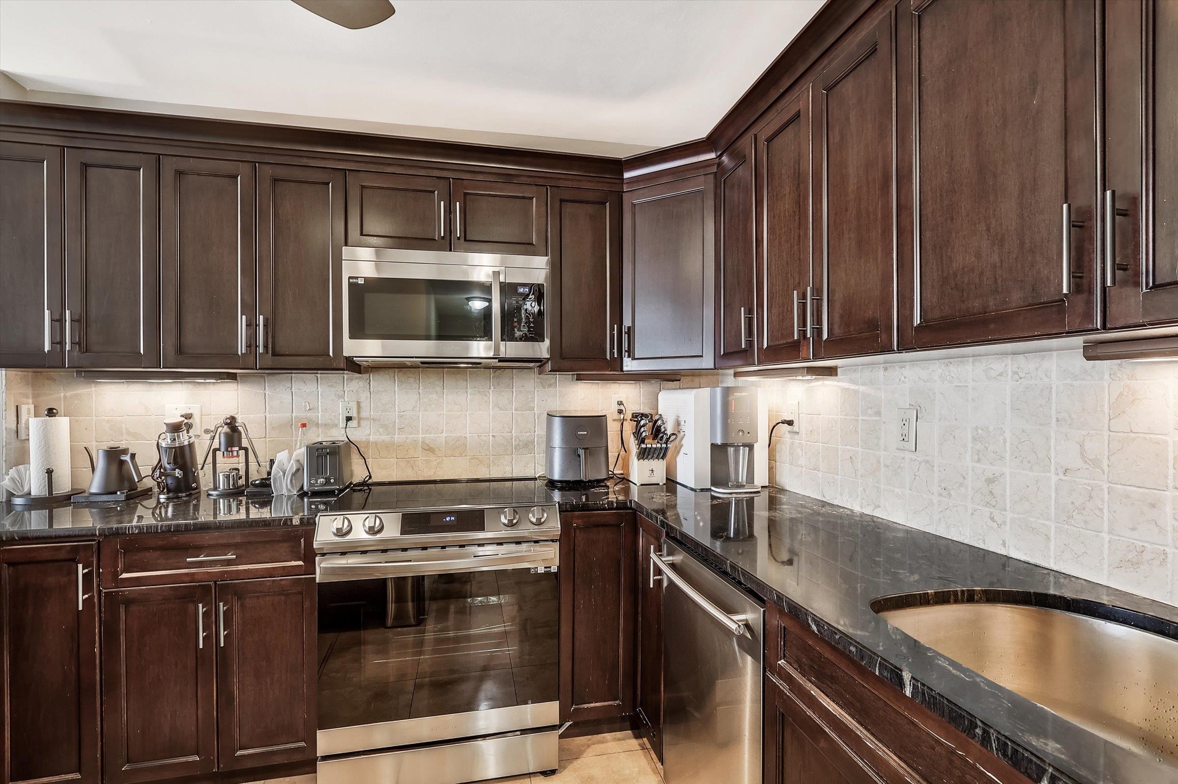 380 Mountain Road, Unit 1015 Union City, NJ 07087 - Photo 18 of 43 a kitchen with granite countertop a stove a microwave a sink and cabinets