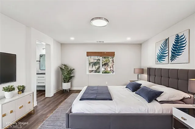 a bedroom with a large bed and a flat screen tv