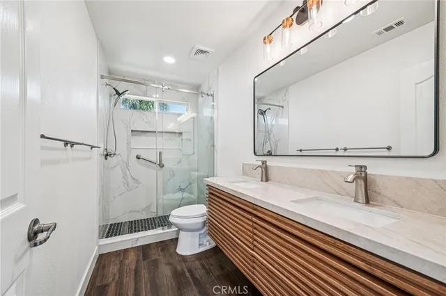 a bathroom with a sink a toilet and shower